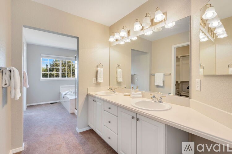 A bathroom with a large mirror and lights above it.