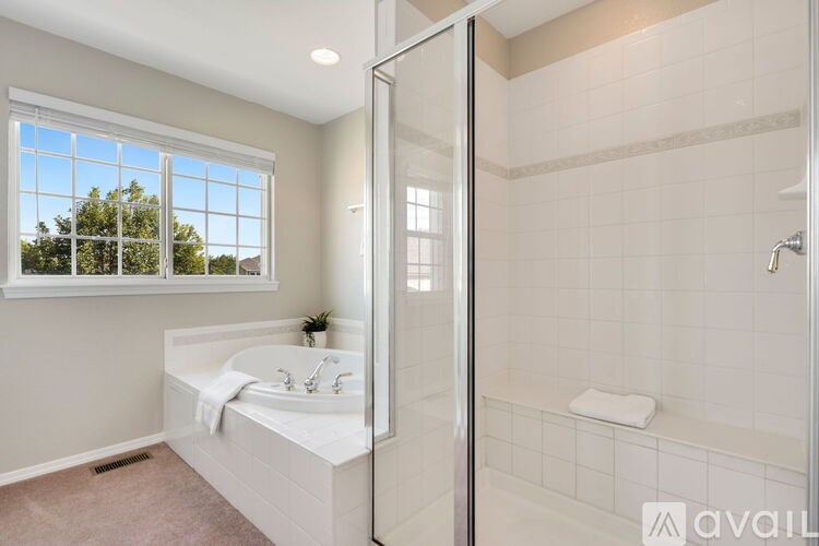 A bathroom with a large window and a walk-in shower.