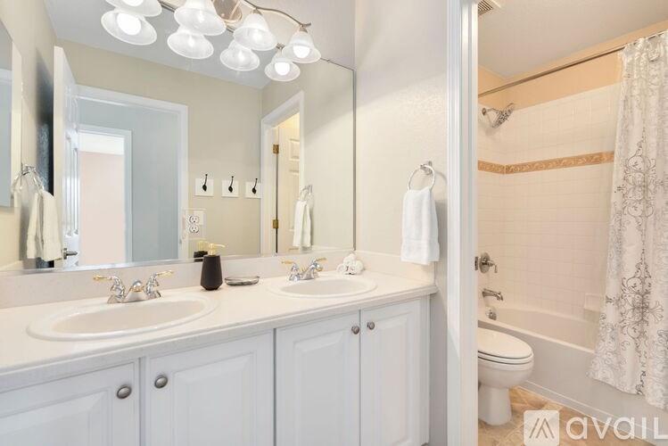 A bathroom with a white sink and a white toilet.