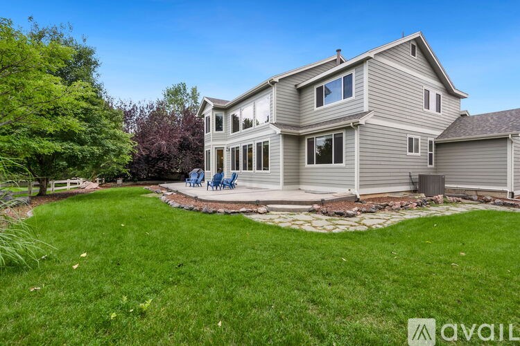 A house with a well-maintained lawn and a stone patio area.