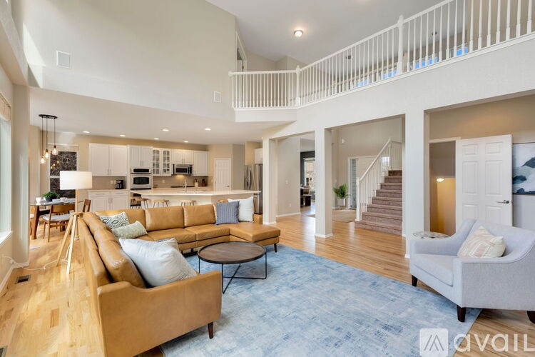 A living room with a tan couch and a blue rug.