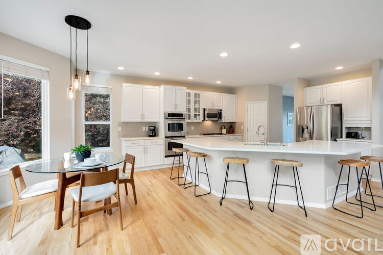 A modern kitchen with a dining table and chairs.