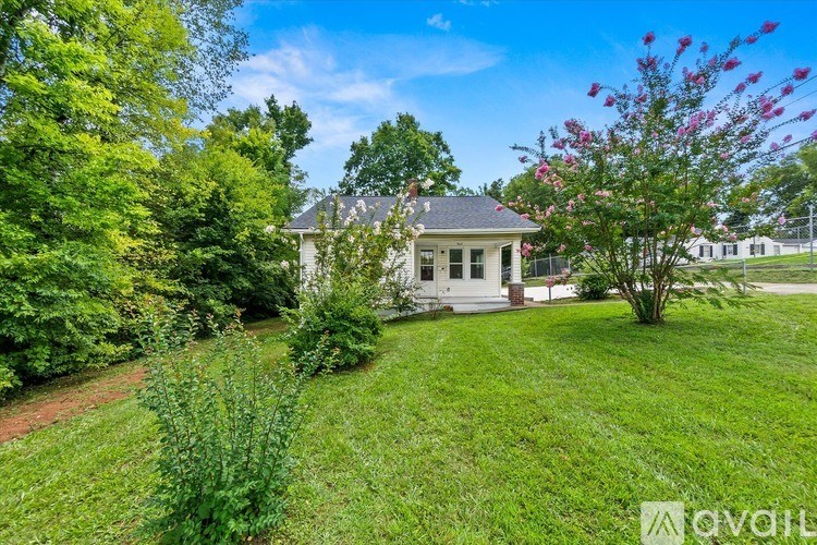 A house with a white fence and a green lawn.
