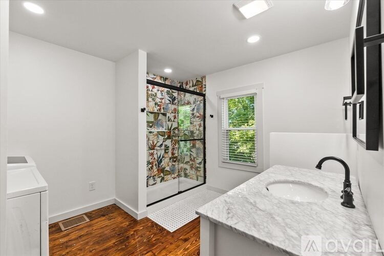 A bathroom with a marble countertop and a walk-in shower.