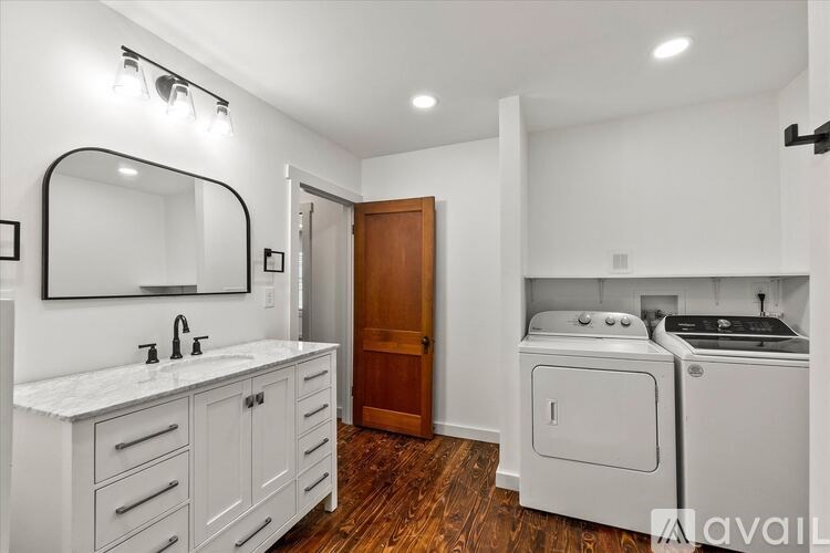 A bathroom with a white vanity and a wood door.