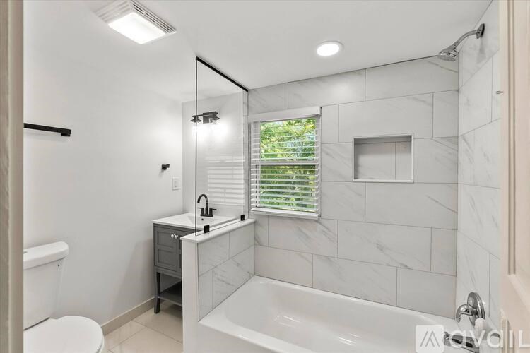 A white bathroom with a tub, toilet, and sink.