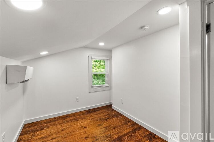 A room with a window and wooden floors.