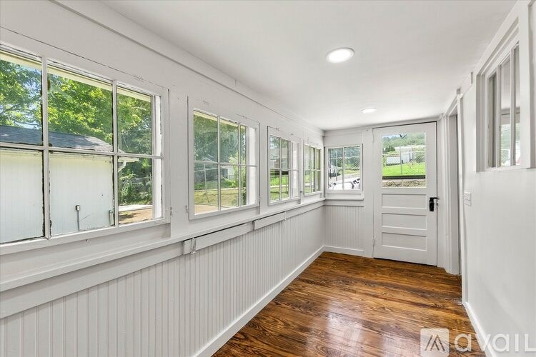 A sunny day at the house with a white door and windows.