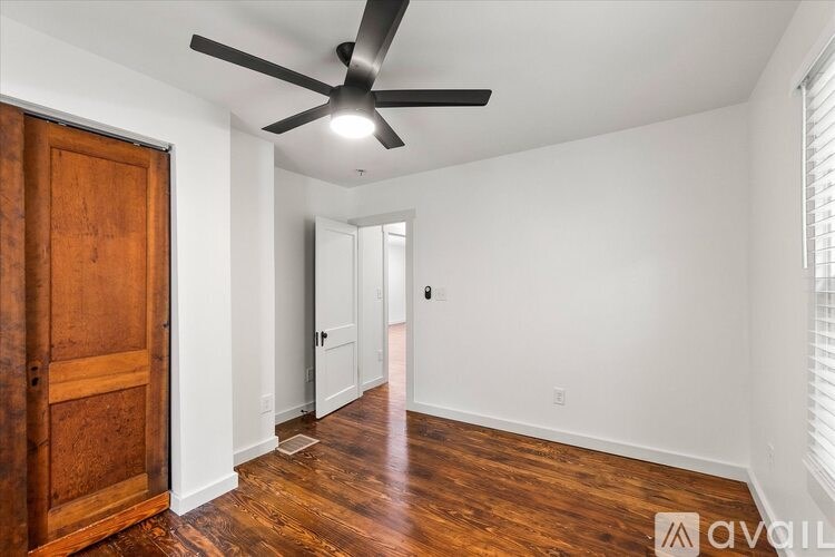 A room with a wooden floor and a ceiling fan.