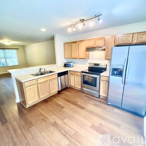 A kitchen with wooden cabinets and a refrigerator.