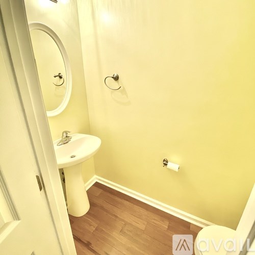 A small white sink in a small bathroom.