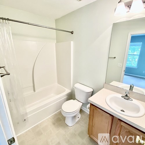 A bathroom with a toilet, sink, and bathtub.