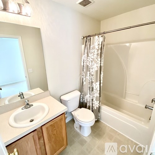A bathroom with a toilet, sink, and bathtub.