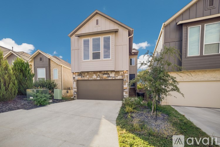 A house with a brown garage door is in front of other houses.