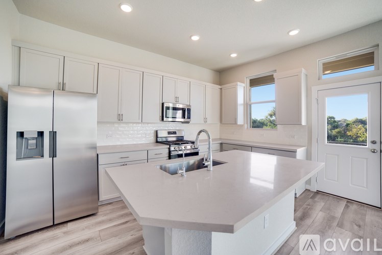 A kitchen with a refrigerator, microwave, and oven.