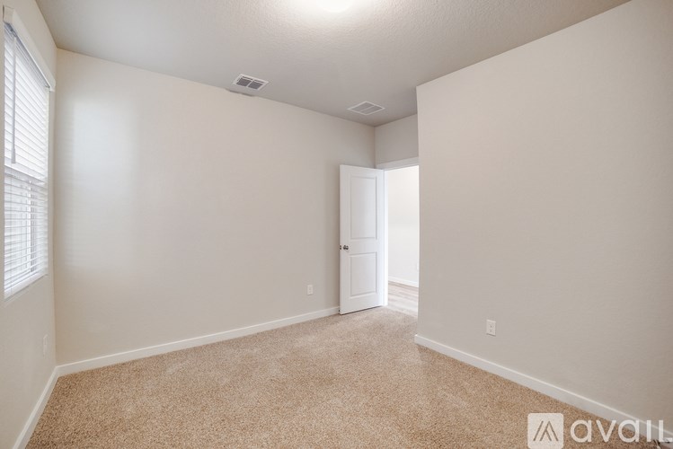 A room with a carpeted floor and a door leading to another room.