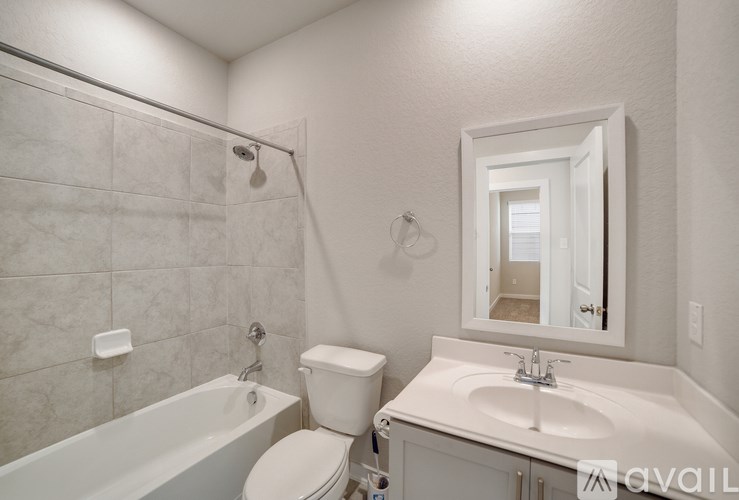 A bathroom with a white toilet, sink, and bathtub.