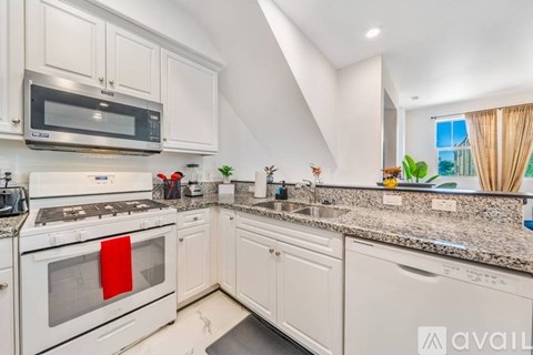A kitchen with white appliances and cabinets.