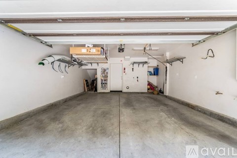 A large, empty garage with a concrete floor and white walls.
