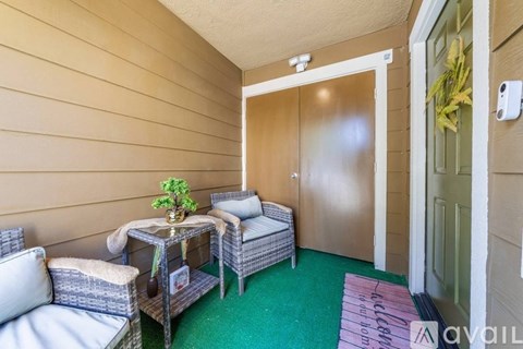 A small balcony with a table and chairs.