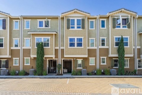 A row of townhouses with a clear blue sky above them.