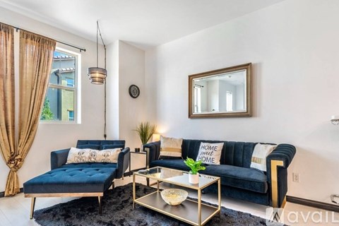 A living room with a black sofa and a coffee table.