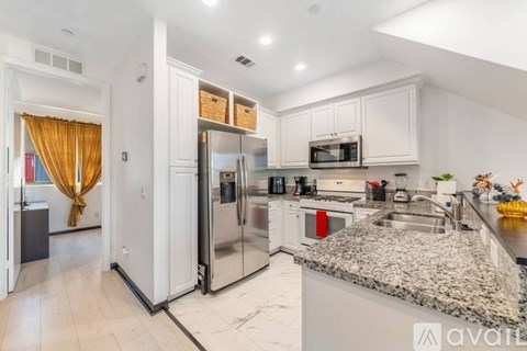 A kitchen with granite countertops and stainless steel appliances.