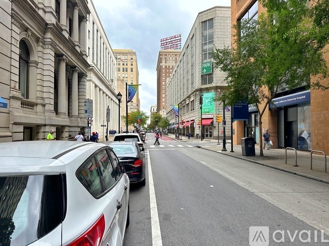 Cars parked on the side of a street with buildings in the background.