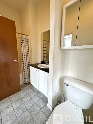 A bathroom with a toilet, sink, and mirror.
