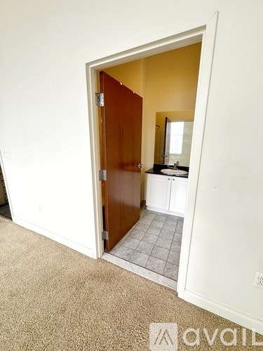 A bathroom with a sink and a mirror is visible through an open door.