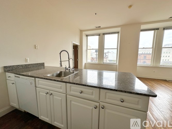 A kitchen with white cabinets and a granite countertop.