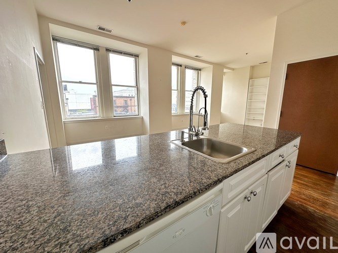 A kitchen with granite countertops and white cabinets.