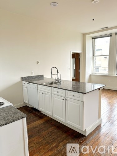 A kitchen with white cabinets and a granite countertop.