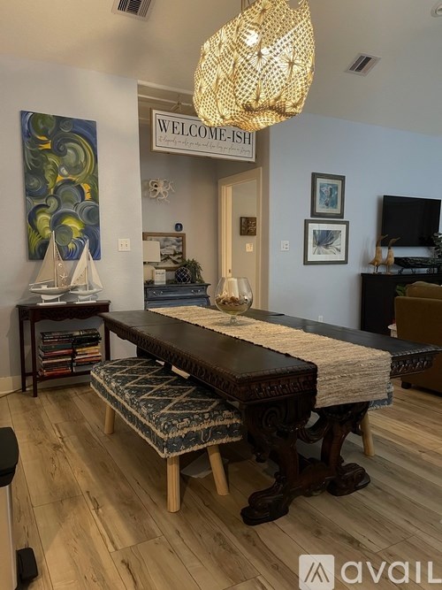 A room with a wooden table and a chandelier hanging from the ceiling.
