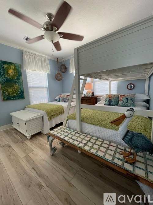 A room with a bed, a chair, and a ceiling fan.