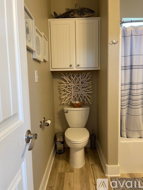 A small bathroom with a toilet and a cabinet above it.