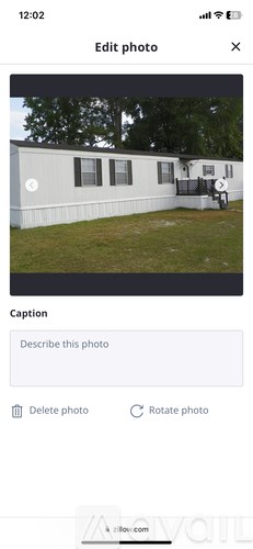 A white house with a black roof and a small porch.