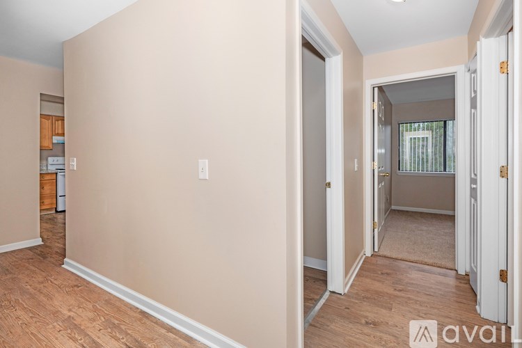 A room with beige walls and wooden flooring is available for rent.