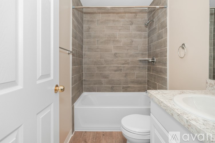 A bathroom with a white toilet, a white door, and a marble counter.