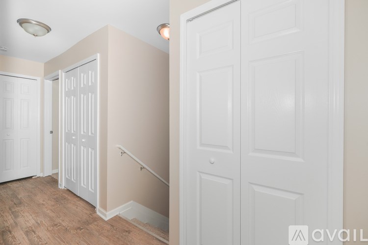 A hallway with white doors and a wooden floor.