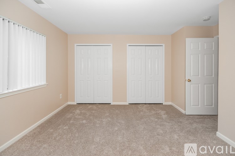 A room with three white doors and a carpeted floor.