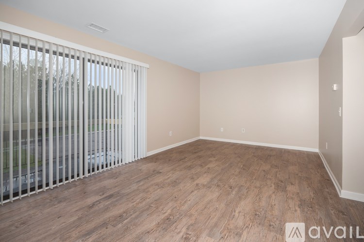 A room with wooden flooring and a sliding glass door.