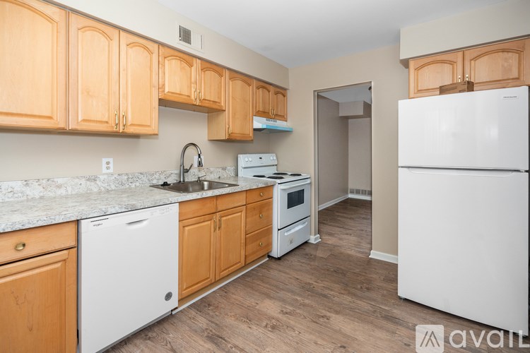 A kitchen with wooden cabinets and white appliances.