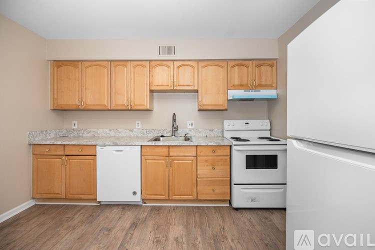 A kitchen with wooden cabinets and white appliances.