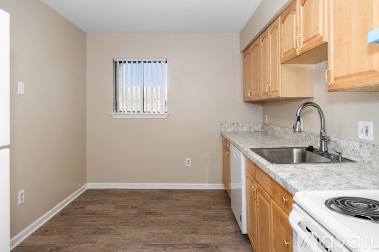 A kitchen with wooden cabinets and a white stove top oven.
