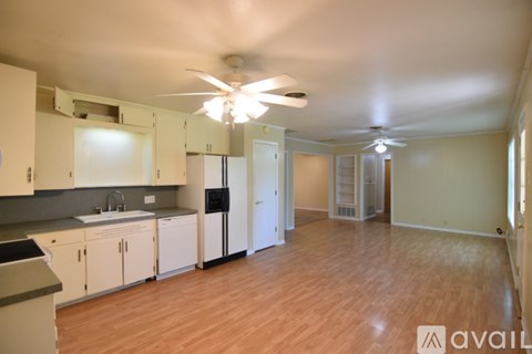 A kitchen with white cabinets and a wooden floor.