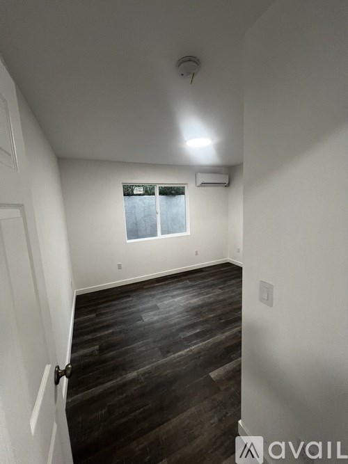 A room with a window and wooden floors.