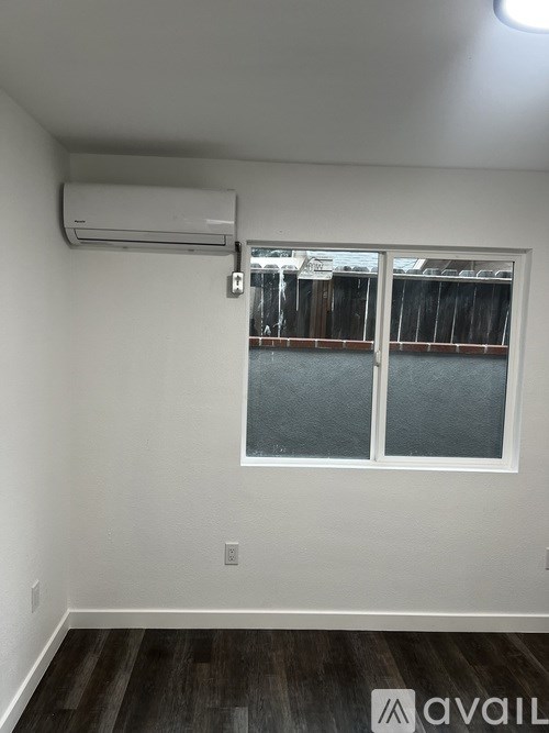A room with a window and a wall-mounted air conditioner.