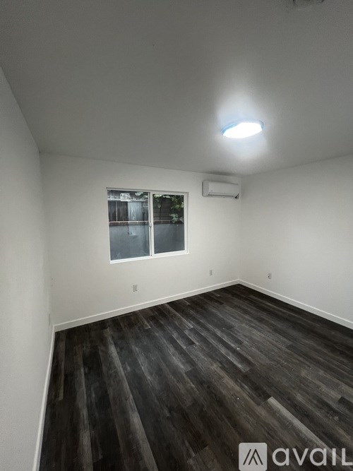 A room with wooden flooring and a window.