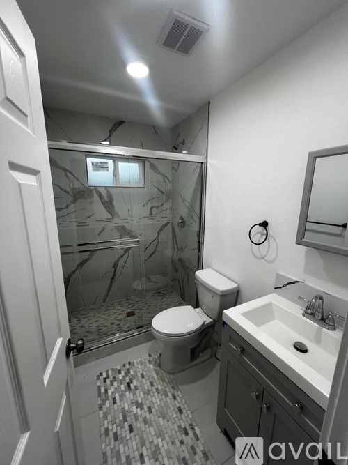 A bathroom with a toilet, sink, and shower.